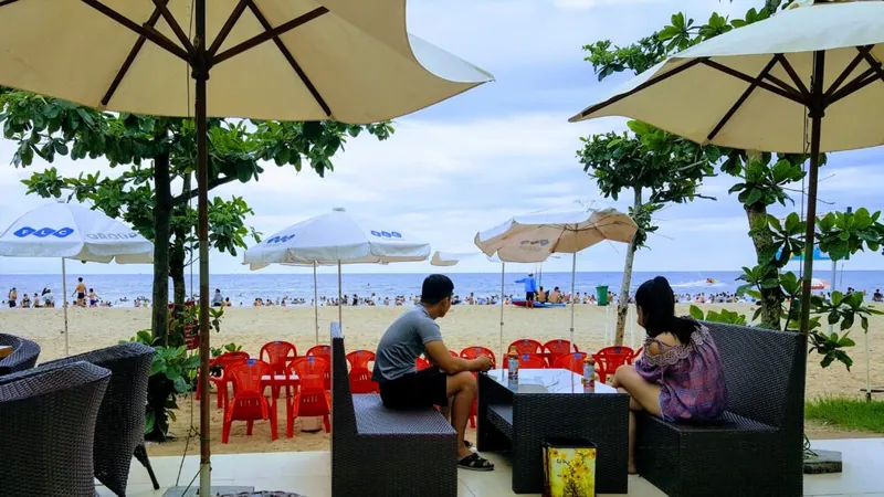 Terras met parasols aan een zandstrand